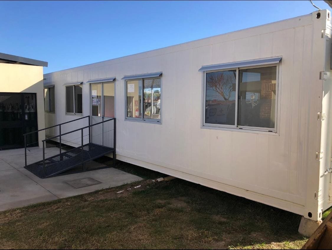 Exterior de una casa contenedor blanca con ventanas